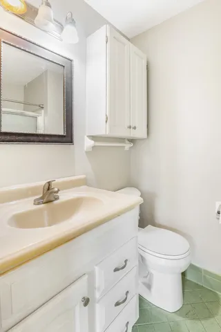 a bathroom with a sink a toilet and mirror