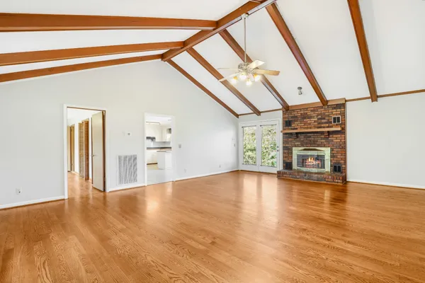 a view of a livingroom with wooden floor and furniture