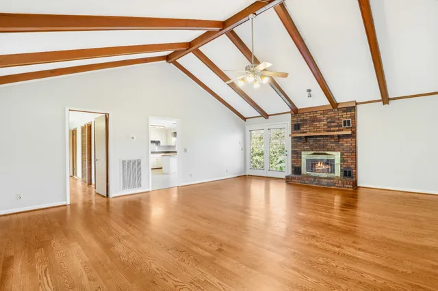 a view of a livingroom with wooden floor and furniture