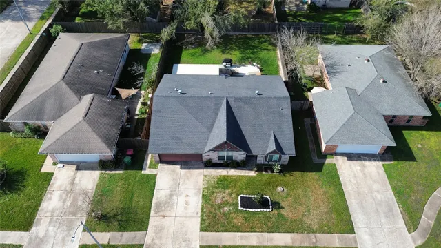an aerial view of residential houses with outdoor space and trees