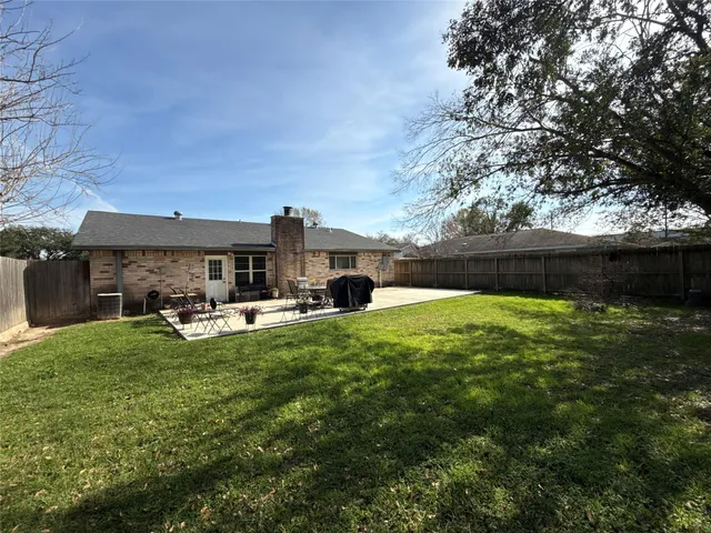 a view of a house with backyard and sitting area