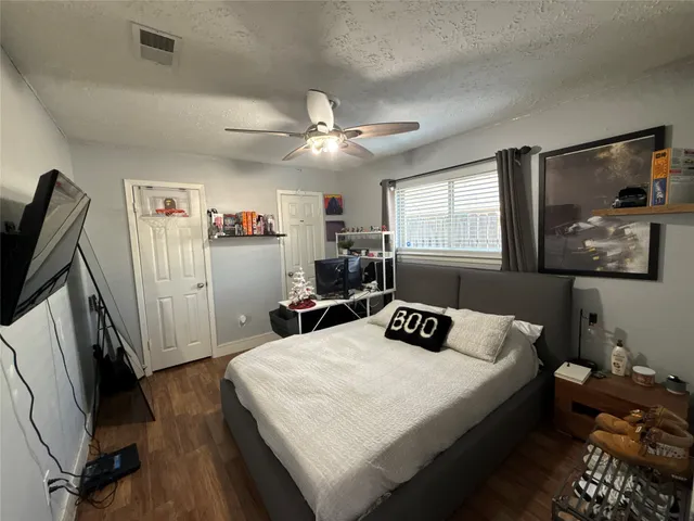 a bedroom with a bed and a flat tv screen on the dresser