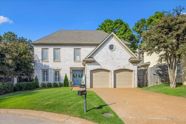 a front view of a house with a garden and yard