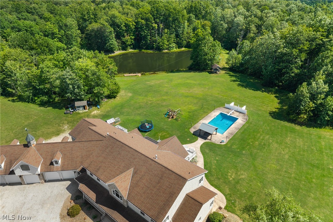 9419 Robinson Road Chardon, OH 44024 - Photo 12 of 49 Expansive green lawn featuring a large swimming pool with covered seating, a natural pond with a dock, and a gazebo