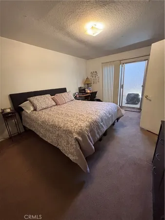 a bed sitting in a spacious bedroom next to a window