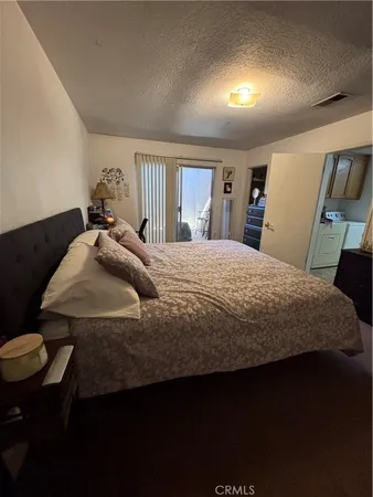 a bedroom with a bed a dresser and chair