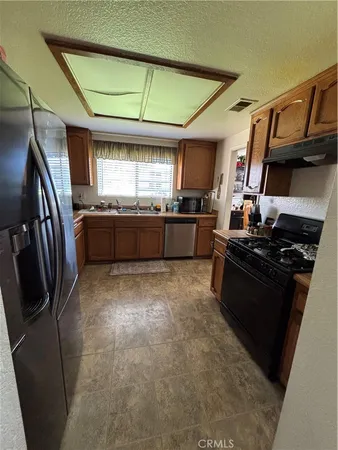 a large kitchen with stainless steel appliances granite countertop a stove sink and cabinets