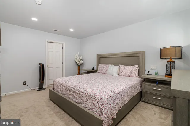 a bedroom with a bed and a refrigerator