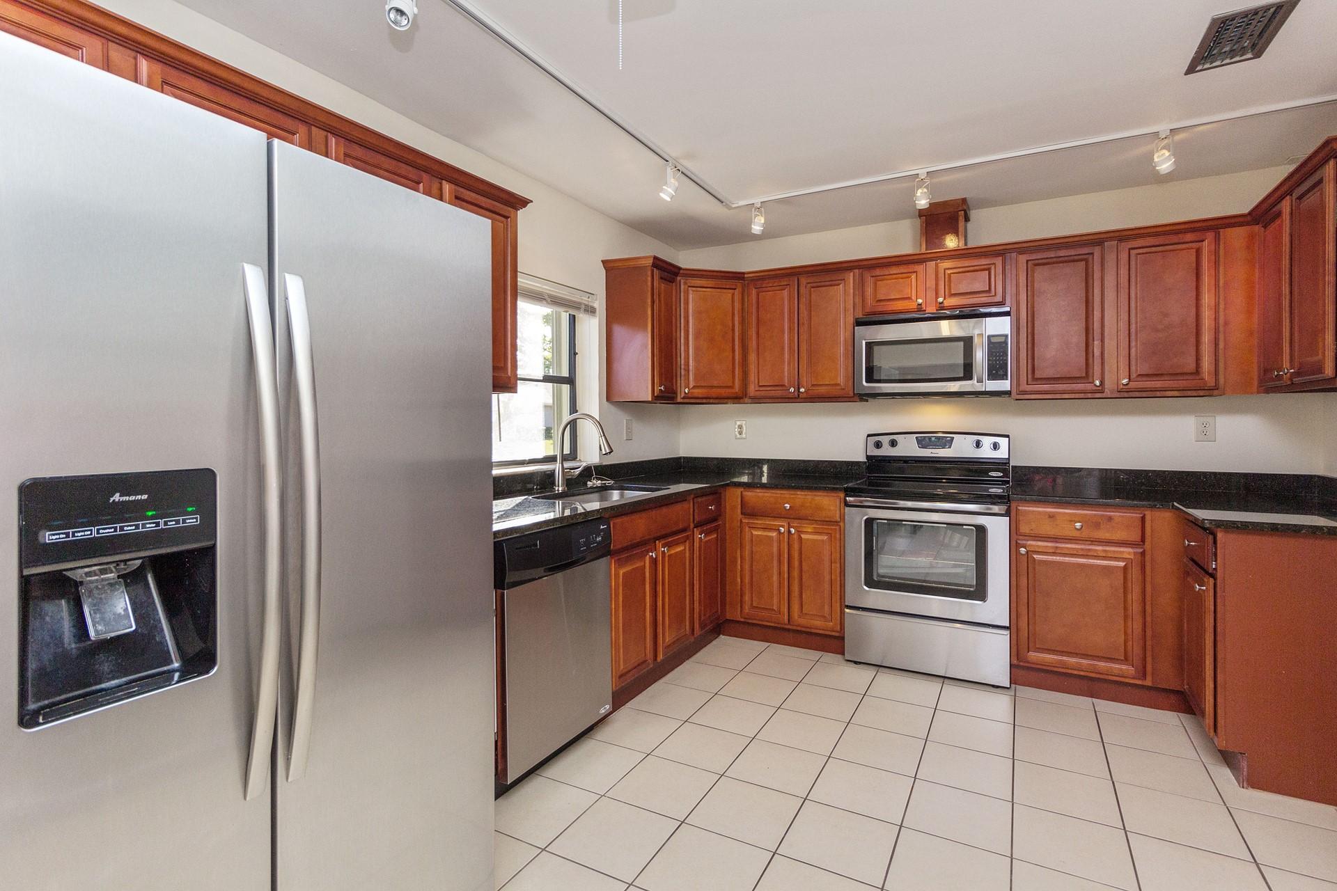 7883 Cloverfield Circle Boca Raton, FL 33433 - Photo 8 of 25 a kitchen with stainless steel appliances granite countertop a refrigerator and a stove top oven