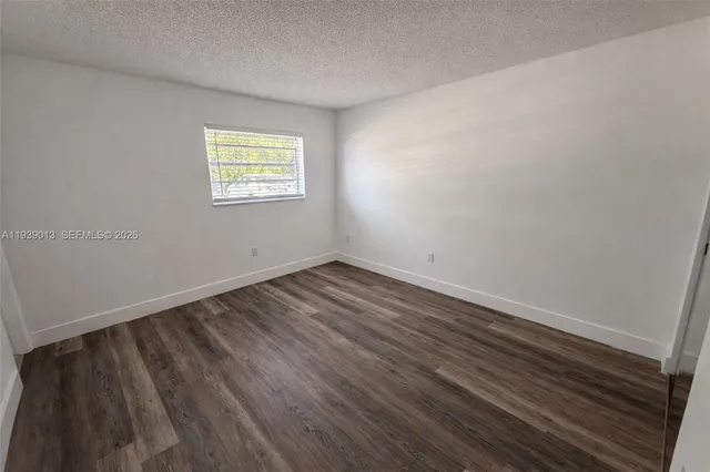 a view of a room that has wooden floor and window