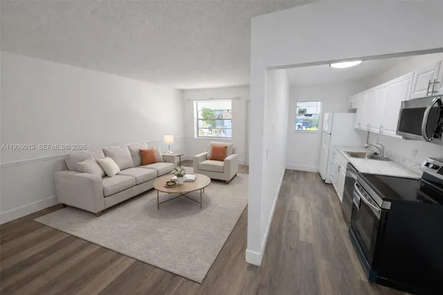 a living room with furniture a flat screen tv and a wooden floor