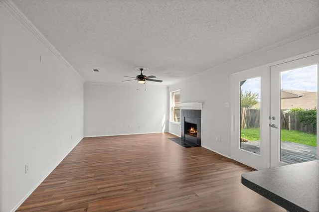 a view of empty room with wooden floor and fireplace