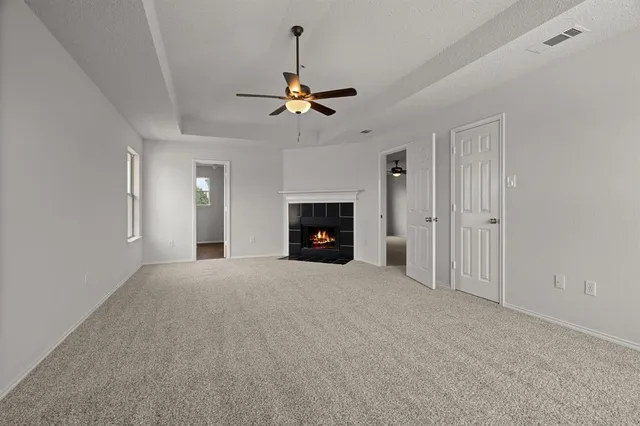 a view of empty room with fireplace and fan