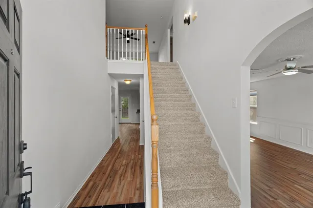 a view of a hallway with wooden floor and staircase