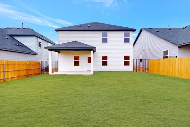 a backyard of a house with table and chairs