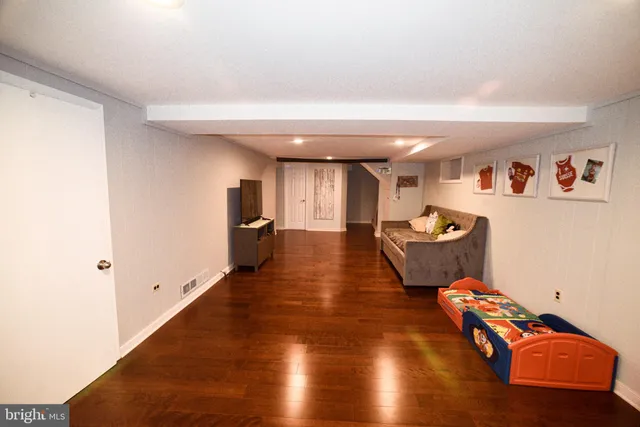 a view of a room with wooden floor and furniture