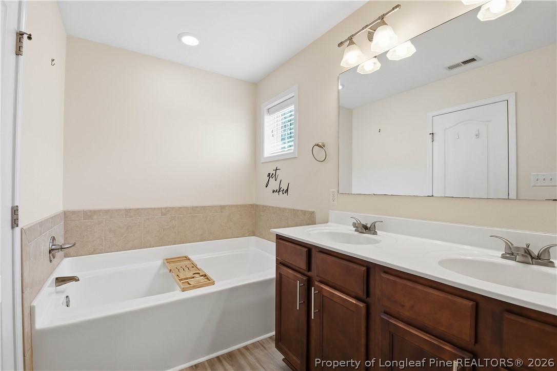 140 Birch Avenue Spring Lake, NC 28390 - Photo 47 of 49 a bathroom with a tub a sink and mirror
