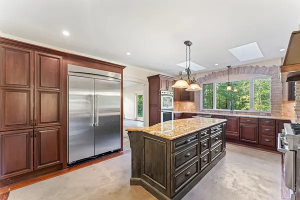 a kitchen with kitchen island a sink stove and refrigerator