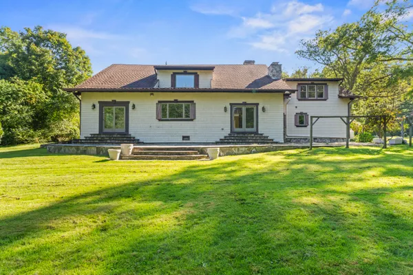 a view of a house with backyard and a tree