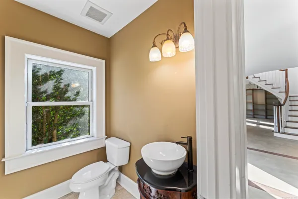 a bathroom with a toilet a sink and a window