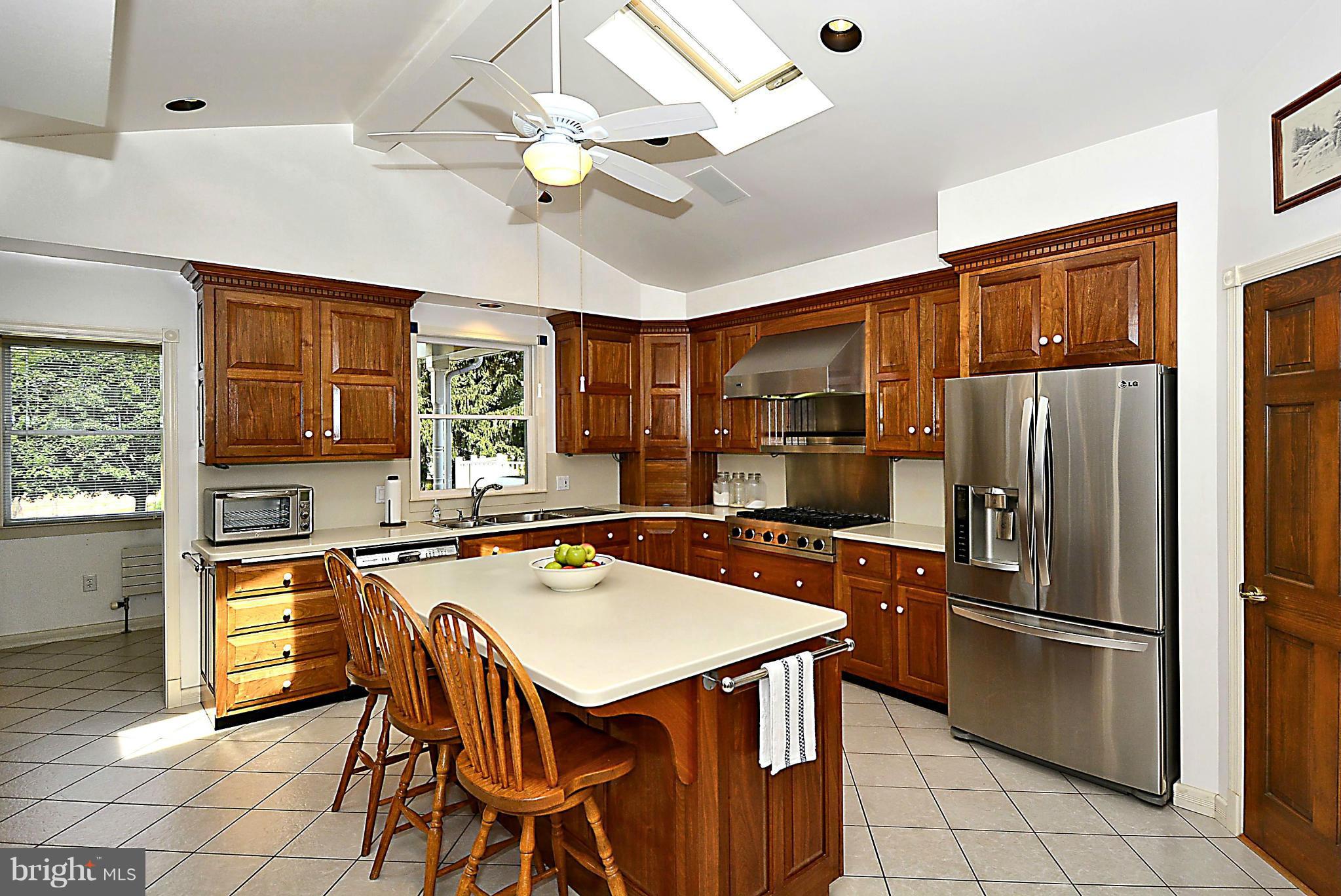 21121 Peach Tree Road Dickerson, MD 20842 - Photo 10 of 30 a kitchen with stainless steel appliances kitchen island granite countertop a refrigerator a stove a sink a dining table and chairs with wooden floor