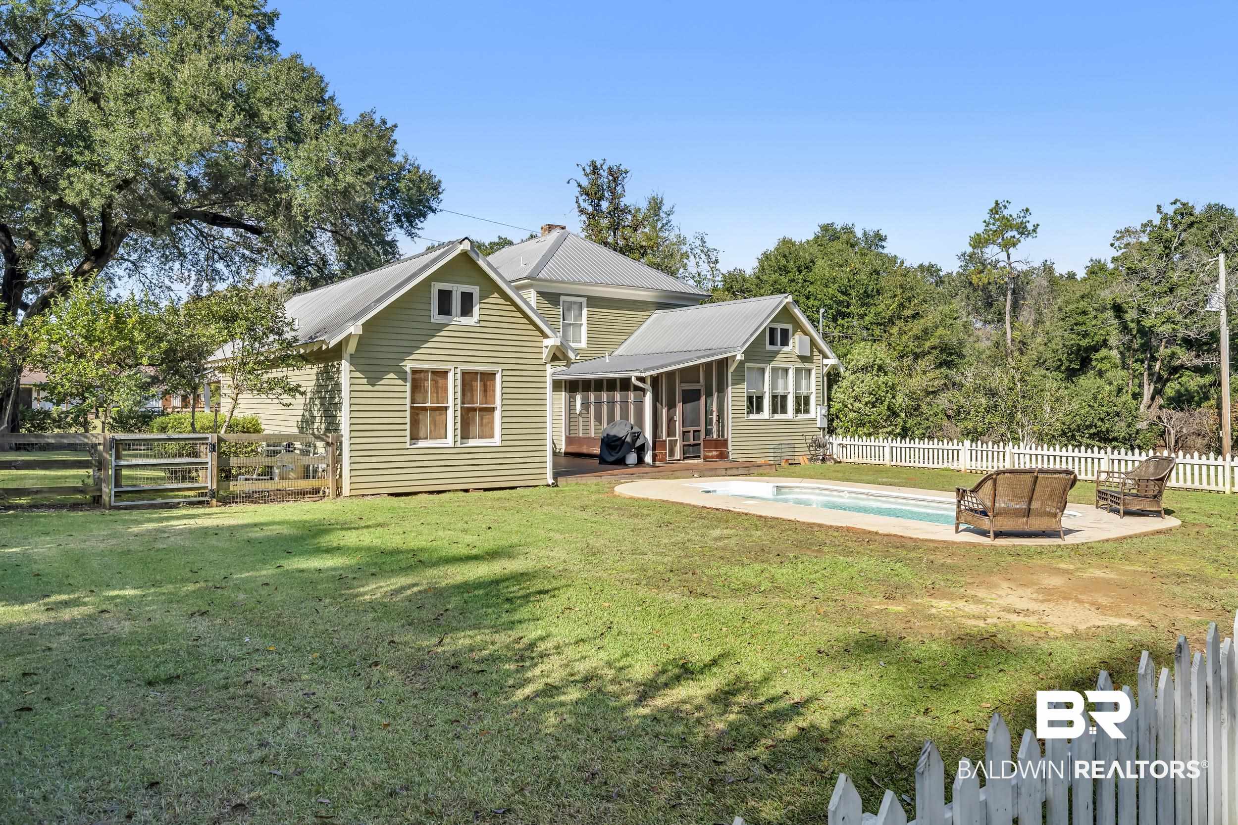 13232 Mary Ann Bch Road Fairhope, AL 36532 - Photo 57 of 79 Back of house with a fenced backyard, a sunroom, a metal roof, and a patio area