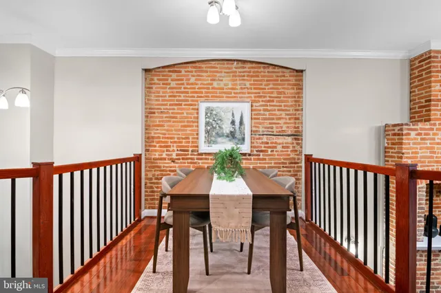 a view of staircase with lots of frames on wall and wooden floor