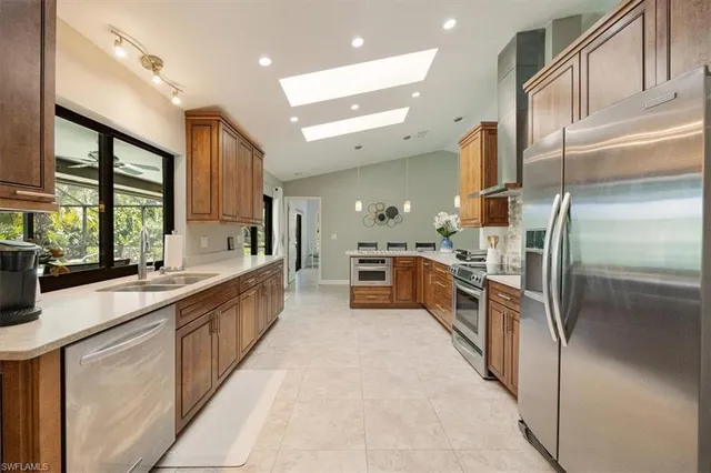 a large kitchen with stainless steel appliances a sink and a stove