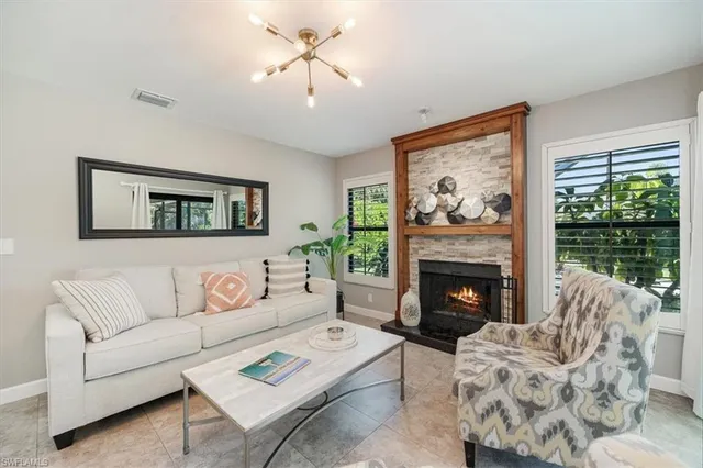 a living room with furniture a fireplace and a large window