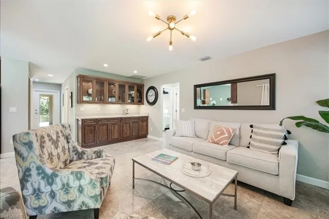 a living room with furniture a fireplace and a chandelier