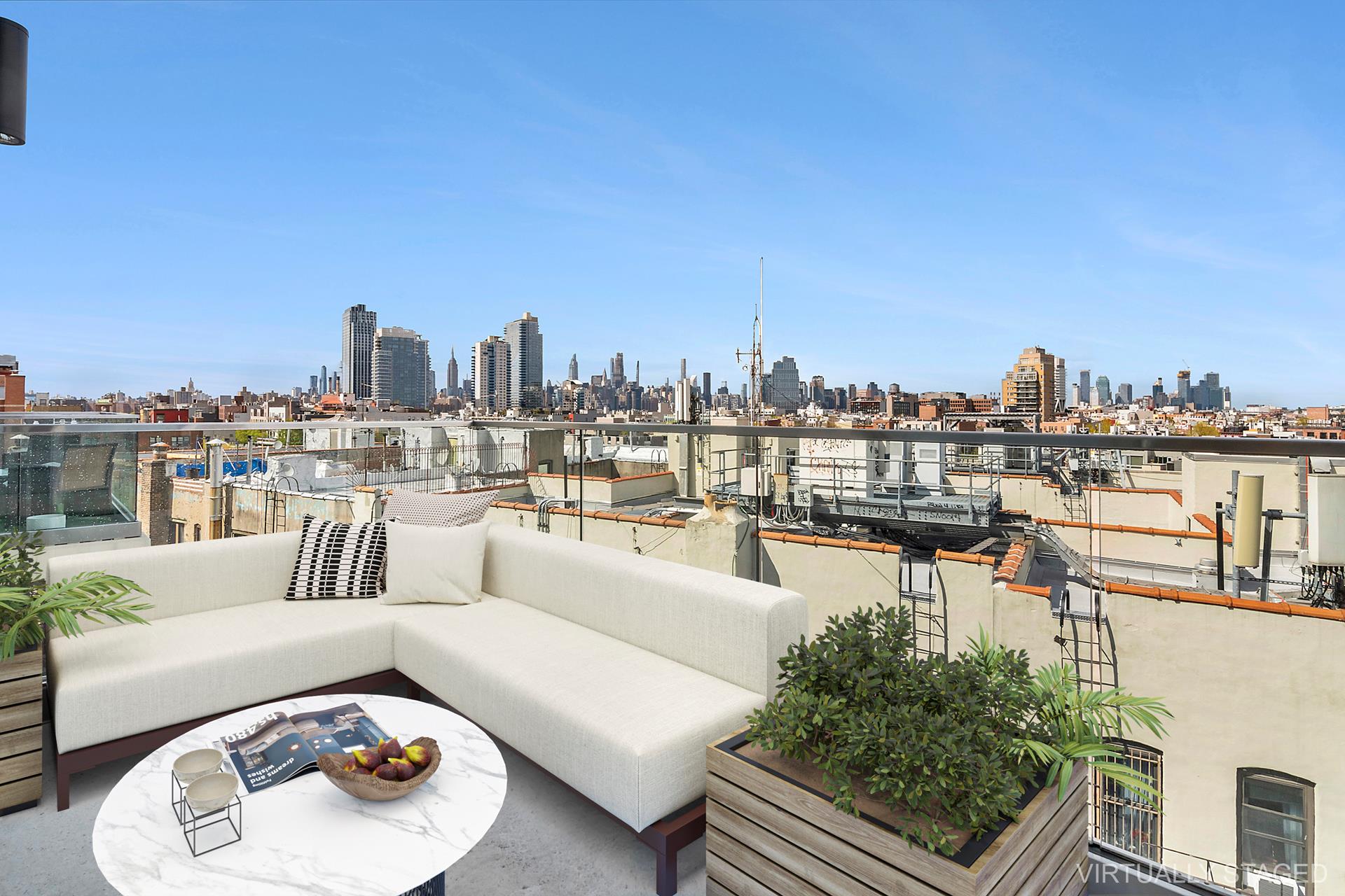 a view of a roof deck with couches and city view