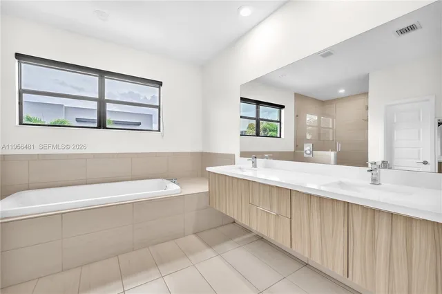 a bathroom with a bathtub a sink and a window