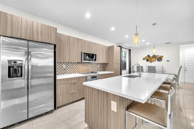 a kitchen with kitchen island a sink stove and refrigerator
