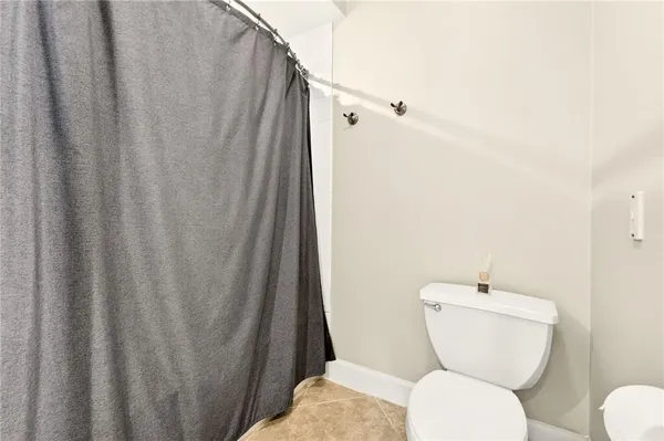 a bathroom with a toilet and a shower curtain