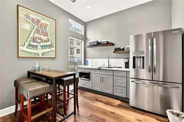 a kitchen with granite countertop a refrigerator and wooden floor