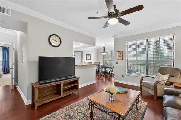 a living room with furniture a flat screen tv and a large window