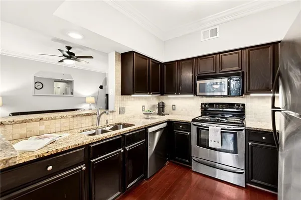 a kitchen with granite countertop stainless steel appliances and sink