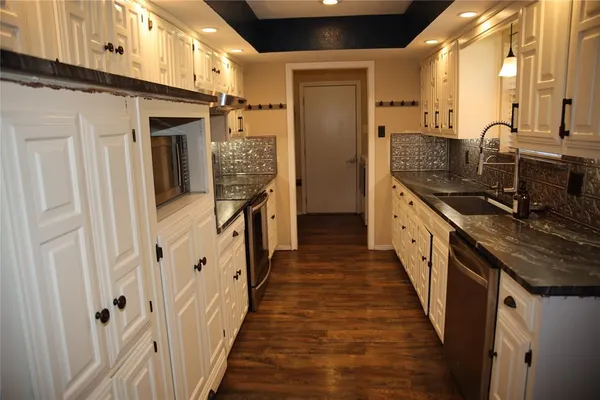 a kitchen with granite countertop a sink and a refrigerator