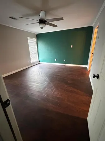 view of a room with a fireplace and a ceiling fan