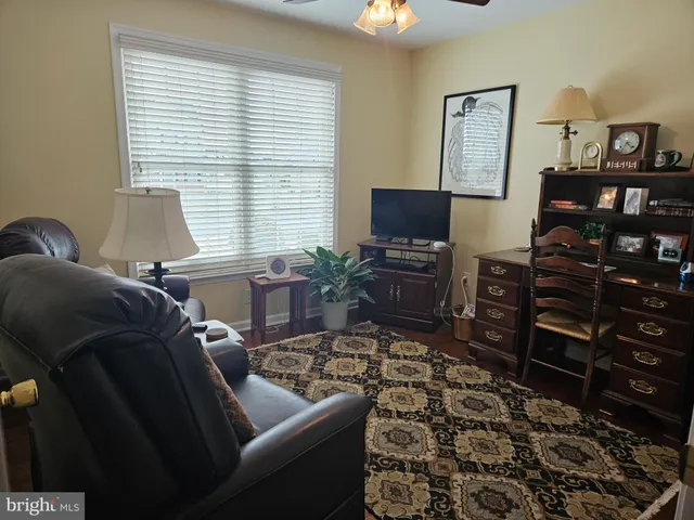 a living room with furniture a flat screen tv and a window