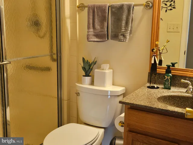 a bathroom with a granite countertop toilet and a sink