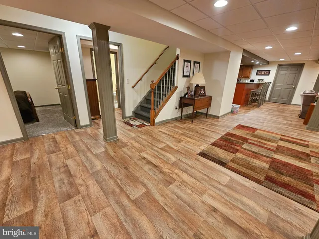 a view of a livingroom with wooden floor and stairs