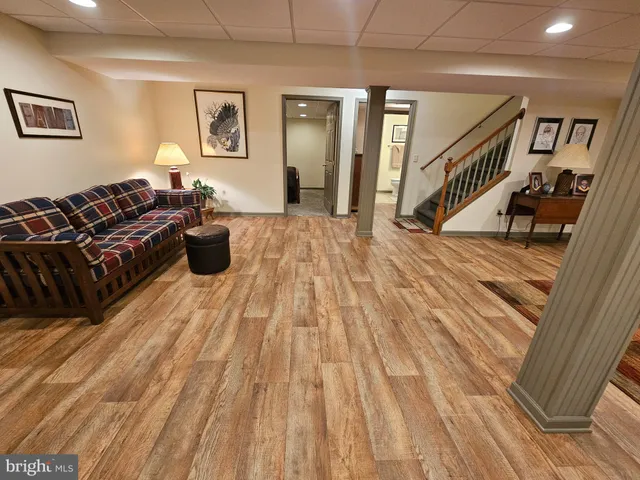 a living room with a couch wooden floor and a ceiling fan