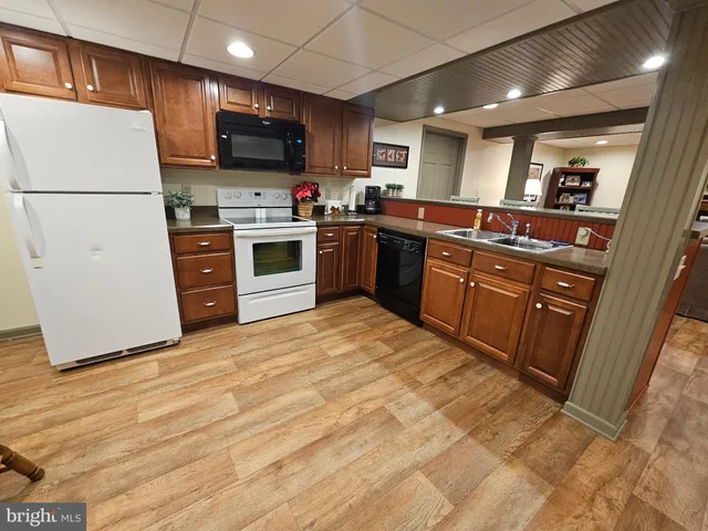 a kitchen with granite countertop a refrigerator stove top oven and sink