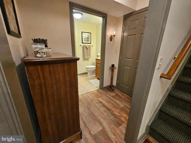 a view of a hallway with wooden floor and stairs