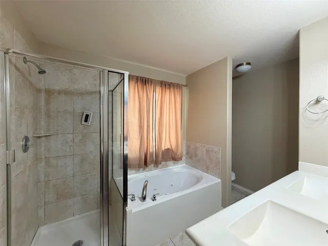a bathroom with a bathtub shower and toilet