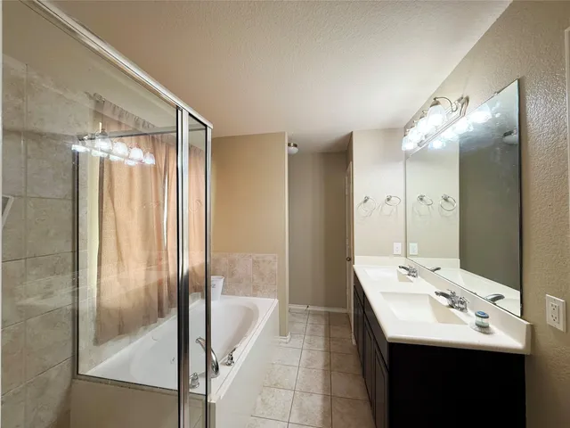a bathroom with a sink shower and a mirror