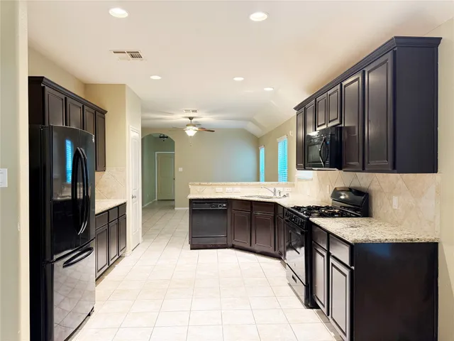 a kitchen with stainless steel appliances granite countertop a refrigerator and a sink