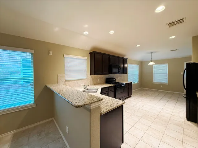 a kitchen with stainless steel appliances kitchen island granite countertop a sink and a microwave