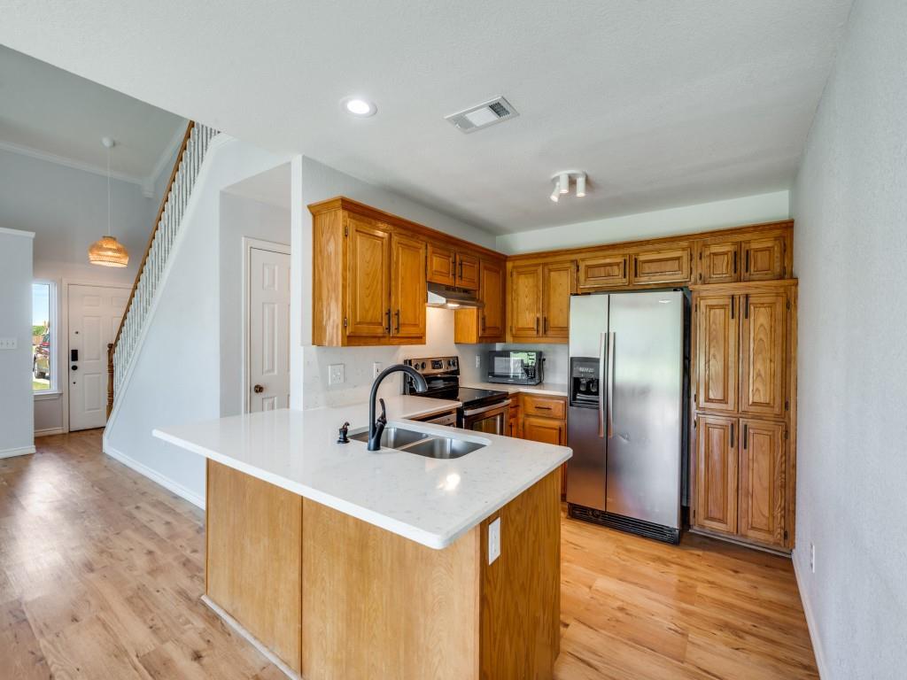 401 North Sierra Trail Pilot Point, TX 76258 - Photo 13 of 30 a kitchen with stainless steel appliances a refrigerator sink and wooden floor
